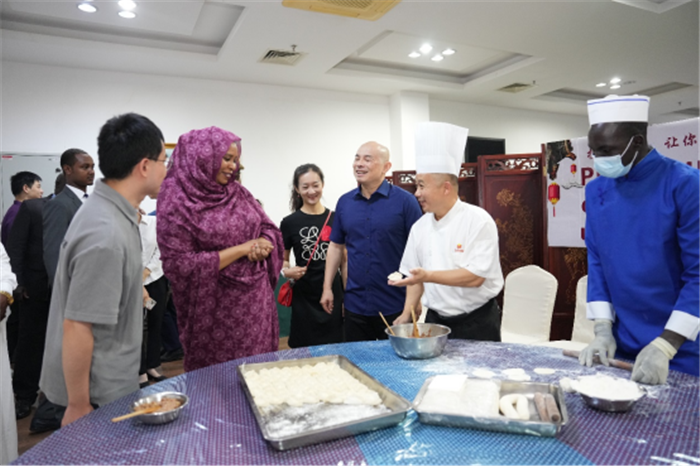 法蒂玛女士（前左二）与中国驻乍得大使王晰宁（右三）观摩包饺子。主办方供图